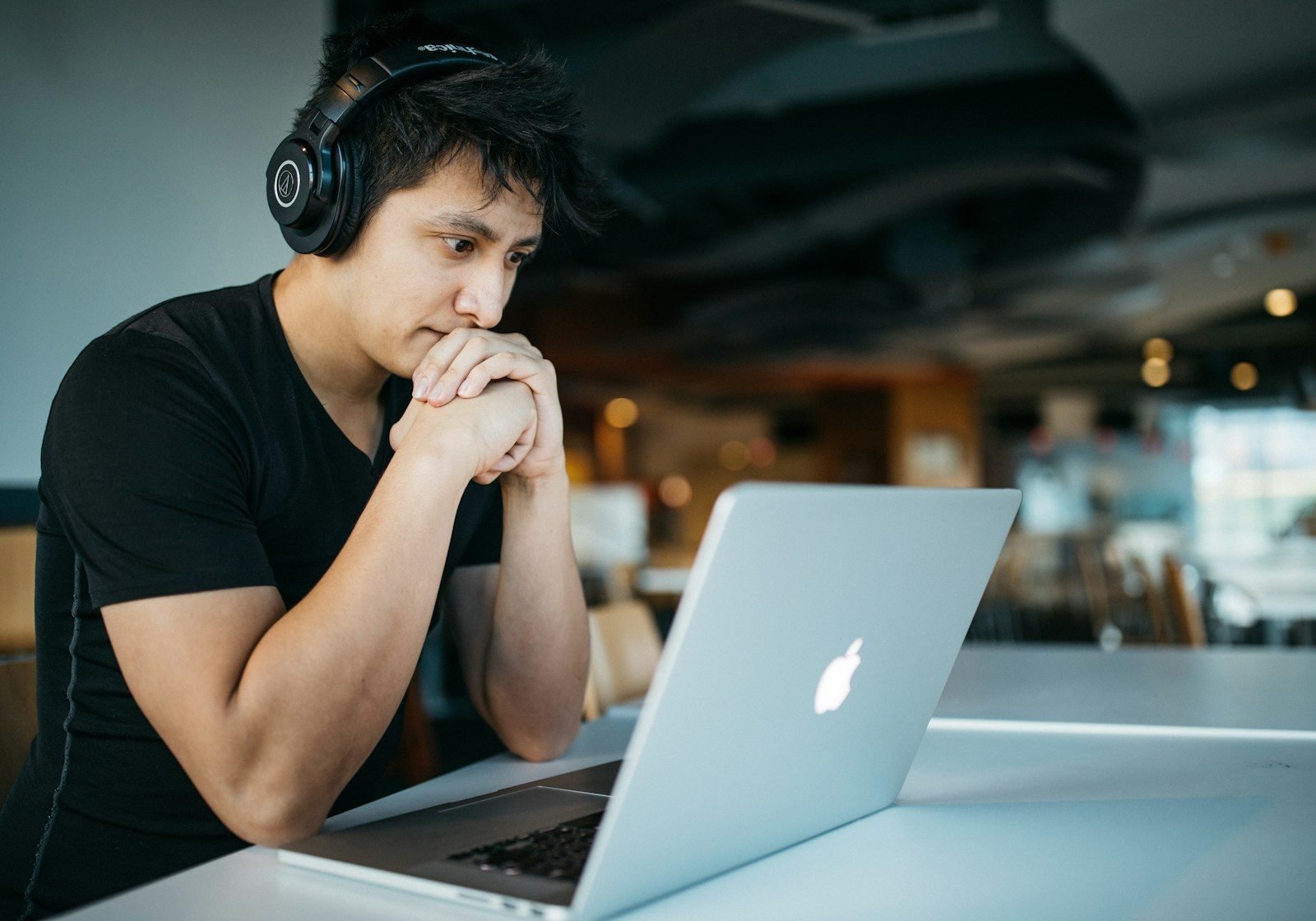Student focused on live online German learning with laptop and headphones